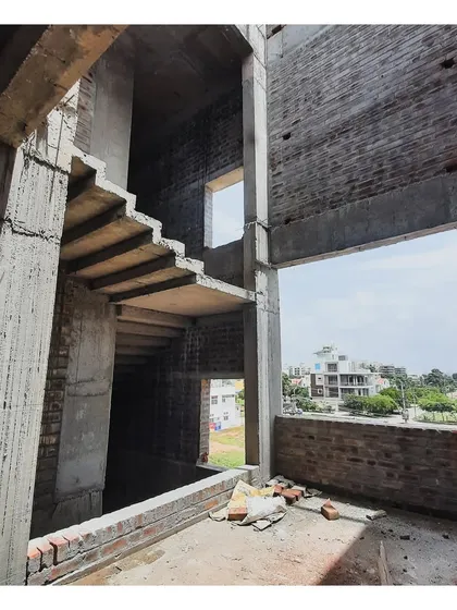 The raw structure of the 'RI' duplex house, showing the concrete frame and staircase before finishing.
