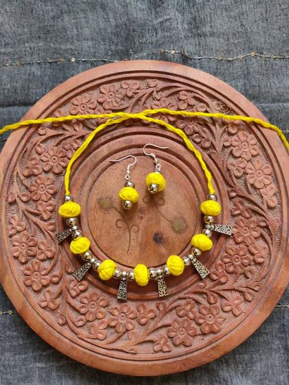 This thread bead necklace is available in a variety of colors like orange, green, yellow, blue, and red. It's a simple yet elegant accessory, perfect for adding a pop of color to your festive wear.