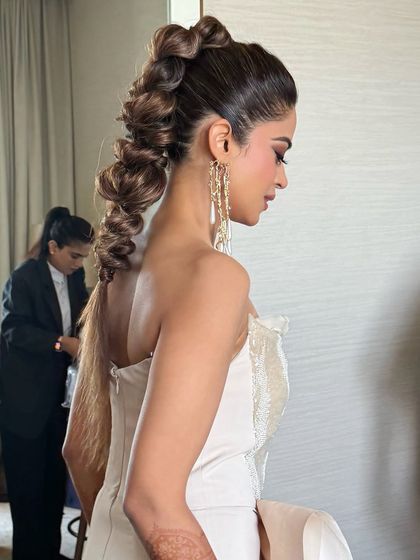 A side view of the voluminous pull-through braid, showing its incredible texture and modern silhouette.