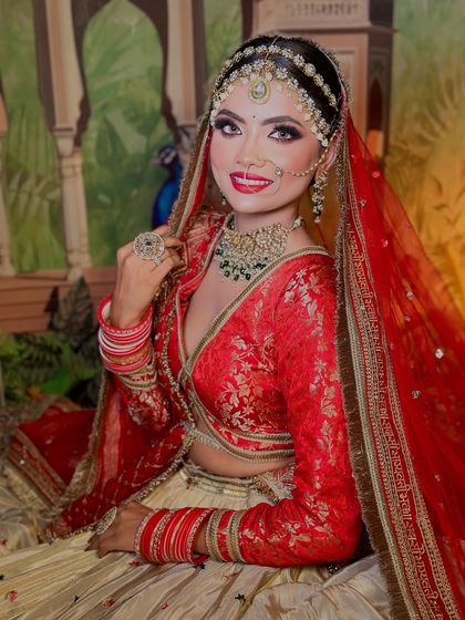 A close-up of the red and off-white bridal look. The makeup features a classic red lip and sharp winged liner, a timeless choice.