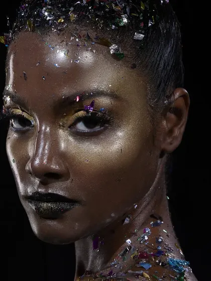 This is where I love to get creative. I crafted an experimental 'glass skin' look with a high-gloss, metallic finish, dark lips, and scattered confetti for a futuristic and avant-garde feel, perfect for high-concept photoshoots.