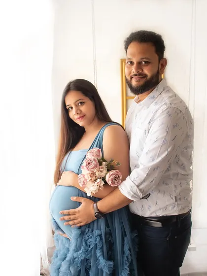 A classic portrait of the expecting couple. Her beautiful blue gown and the soft flowers create a lovely, serene atmosphere for this maternity photo.