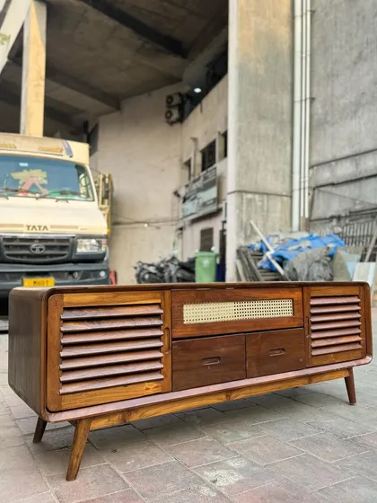 Another angle of the media console, showing the slatted doors.