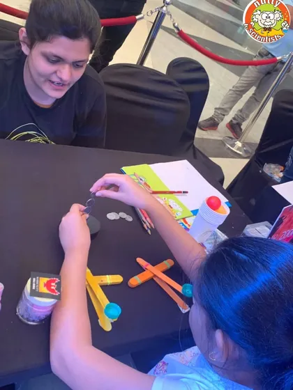 A parent and child work together on their catapult design. Our workshops are great for family bonding and collaborative problem-solving.
