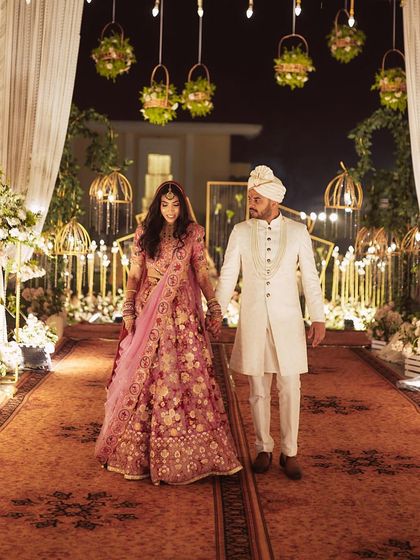 The couple's grand entrance. The lighting highlights the bride's glowing skin and beautiful outfit.