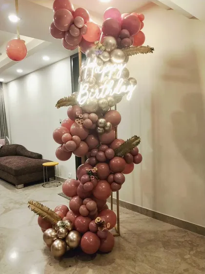 Modern, clean, and classy. Our signature cuboid frame decor is perfect for a stylish celebration, featuring a cascade of rose gold balloons and a custom neon sign to create a chic photo backdrop.