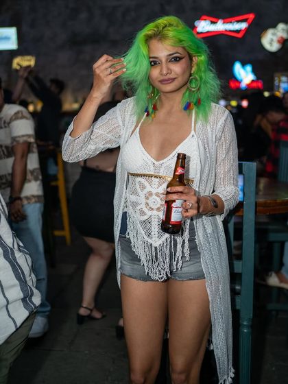 A guest with vibrant green hair, enjoying a beer. My events are all about individual style and having a good time.