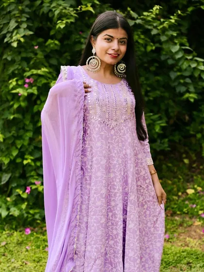 Color and light are everything in outdoor photography. This portrait in a lavender Anarkali suit, set against a lush green background, shows my style for daytime events like the Mehendi or Haldi, capturing vibrant outfits and happy moments.