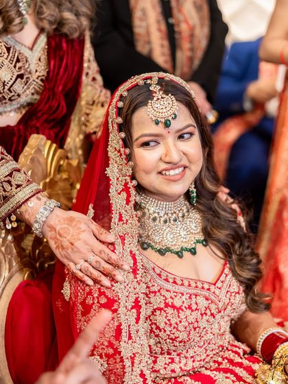 A sweet moment during the wedding ceremony. The bride's soft glam makeup with a focus on glowing skin looks beautiful from every angle.
