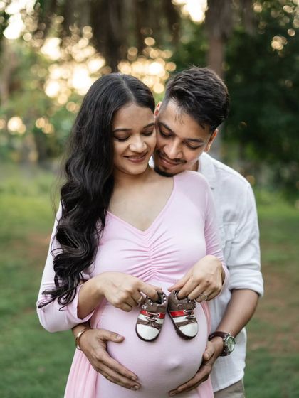 It's all about the tiny shoes! Holding up a pair of baby shoes is such a sweet and classic way to symbolize the little one on the way. This close-up shot during their outdoor session is just adorable.
