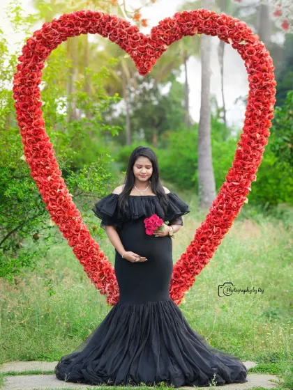 A beautiful solo portrait in a black mermaid-style gown, framed by our red floral heart prop.