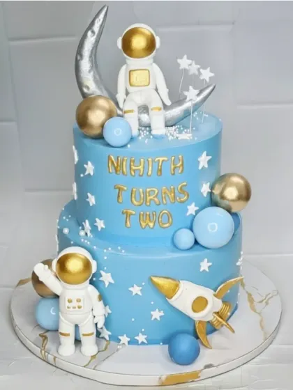 Two the moon! I designed this two-tier space theme cake for Nihith's second birthday. It's a fresh pineapple cake decorated with fondant astronauts, planets, and a rocket ship for an out-of-this-world celebration.