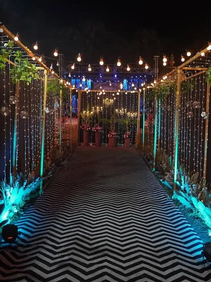 A glamorous entryway for a Sangeet or Reception. The tunnel of fairy lights and modern zig-zag flooring creates a dramatic and exciting entrance for guests.