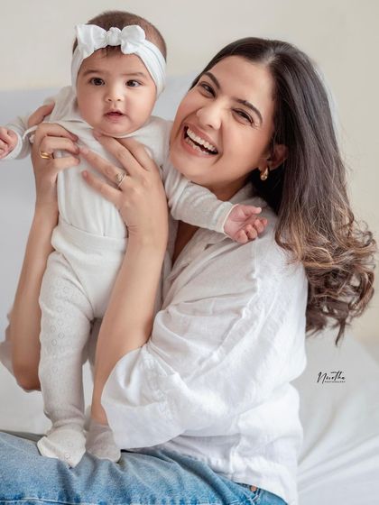 A mother and her baby sharing a joyful, candid moment.