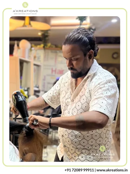 Senior Stylist Krishna at work, meticulously styling a client's hair. Our team's dedication to their craft is what defines the A'Kreations experience.