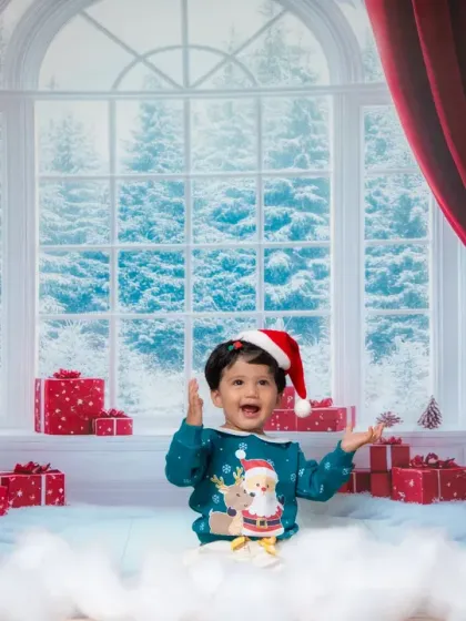 A joyful little boy celebrating Christmas in our winter wonderland studio setup.