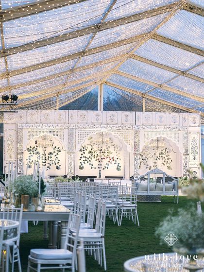 A wide shot of the sangeet setup, showing the seating arrangement facing the grand stage. The layout is designed for optimal viewing and guest comfort.