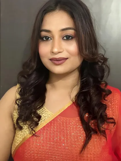 A classic party look with a focus on a flawless base and a defined, matte lip. The soft curls complete this elegant style.
