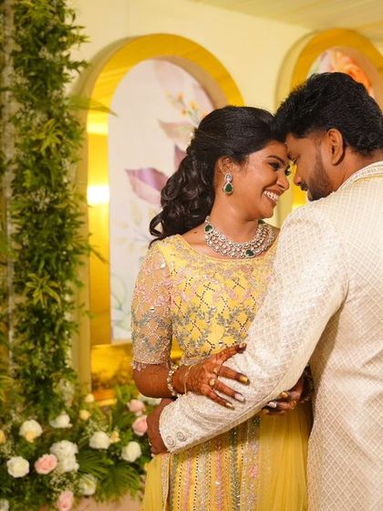 A romantic portrait of my bride Abhinaya and her groom. Her reception look features a bright yellow lehenga, soft curls, and makeup that makes her glow with joy.