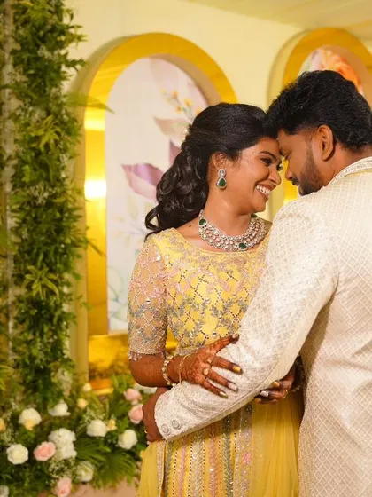 A romantic portrait of my bride Abhinaya and her groom. Her reception look features a bright yellow lehenga, soft curls, and makeup that makes her glow with joy.