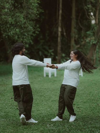 The couple dancing together in a field, her hair flying as she twirls, a moment of carefree joy.