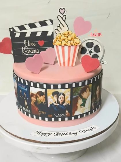 A cute K-Drama cake for Deepti, who is a huge fan of all things Korean. This no-fondant cake features an edible photo reel of her favorite K-dramas, along with popcorn and a movie clapper.
