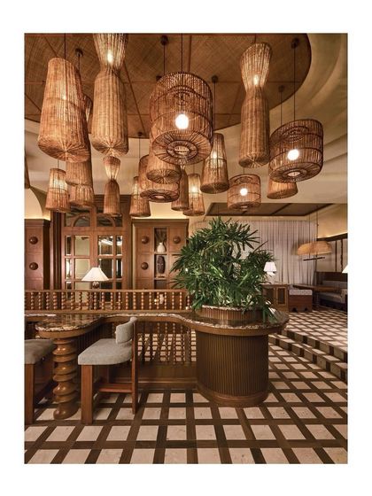 Another perspective from the AD feature, highlighting the checkerboard flooring and the cluster of woven pendant lights. The combination of textures creates a rich, layered, and inviting atmosphere.