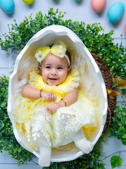 An overhead shot of our little chickadee nestled in her egg. The surrounding greenery adds a fresh, natural touch to this Easter setup.
