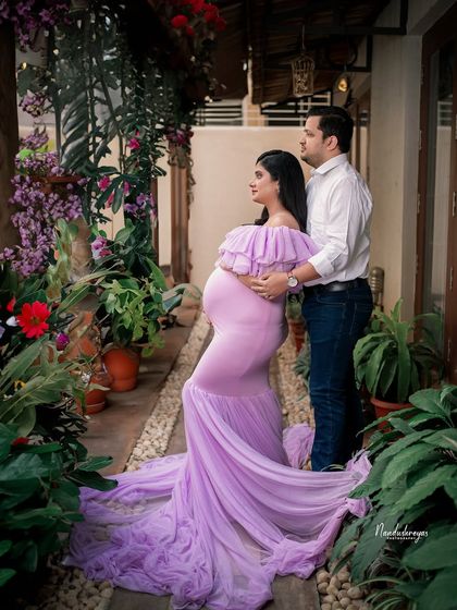 A tender moment between the couple, captured in a narrow garden path. The perspective gives a sense of intimacy and privacy.