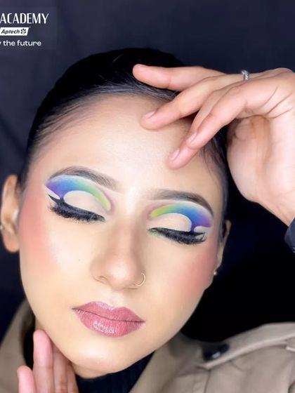 A student's work featuring a multi-color graphic eyeshadow look. The smooth gradient from blue to green and the clean lines demonstrate excellent control and blending skills.