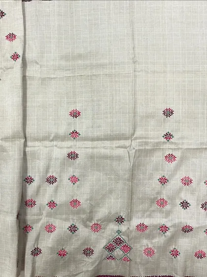 This off-white checked saree is embellished with small, colorful Kasuti butis, growing denser towards the pallu. It's a playful yet traditional design.