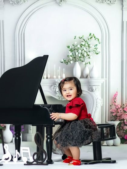 There is no charm equal to tenderness of heart. A happy girl plays the piano in our elegant, white vintage-style studio.