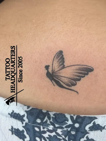 A delicate tattoo of a fairy or a girl with butterfly wings, a whimsical and magical design.
