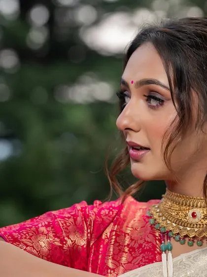 A close-up profile shot from the styled shoot, highlighting the model's makeup and the traditional gold choker.