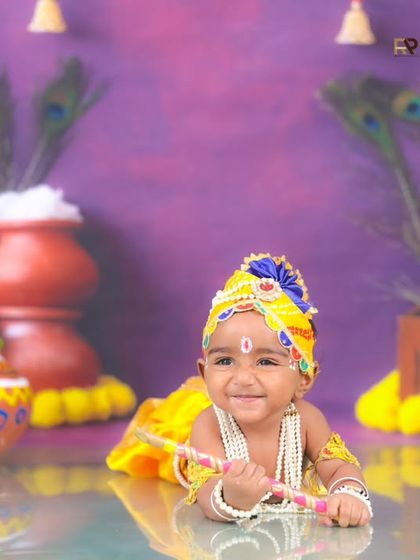 Another joyful shot of our Little Krishna, smiling brightly for the camera. The colorful and detailed setup perfectly captures the spirit of Janmashtami.