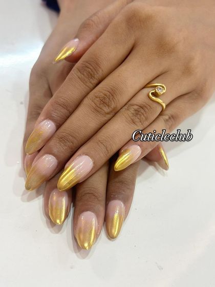 A stunning gold chrome ombre on long stiletto nails. The seamless blend from a nude base to a metallic gold tip is pure luxury.