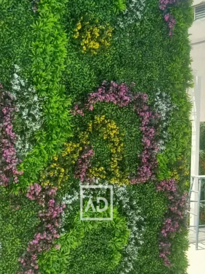 Your walls can be a work of art. This artificial vertical garden shows how I can create custom patterns using different colors and textures of foliage, including purple and yellow floral accents, to match your aesthetic.