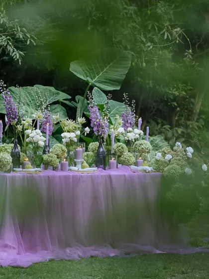 A peek at the romantic tablescape through the surrounding foliage, creating a sense of discovery.