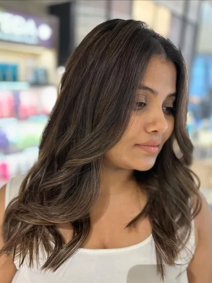 A portrait of summer lovin' hair. The beige highlights on this mid-length cut create a soft, sun-kissed look.