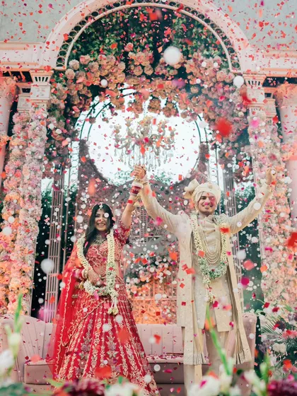 A moment of pure celebration. The explosion of confetti and flowers during the varmala is more than just a picture; it's the feeling of two families becoming one, frozen in time.