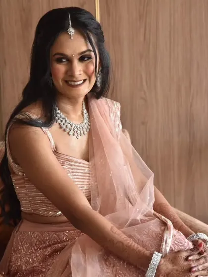 A happy and relaxed portrait. The bride's pastel pink lehenga and diamond jewelry are perfect for a modern engagement ceremony.