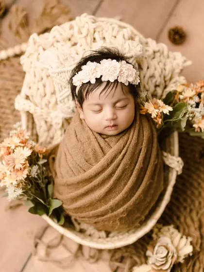 A beautiful baby girl in an earthy, boho-themed setup with natural textures and colors.