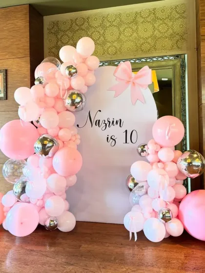 A pretty pink theme for a 10th birthday, with a custom backdrop, large pink balloons, and silver chrome accents.