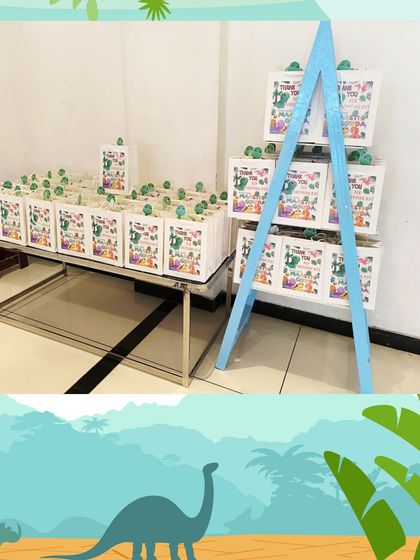 For a dinosaur-themed party, I set up this display of gift bags on a table and a small easel. It shows how the return gifts can be a part of the party decor.