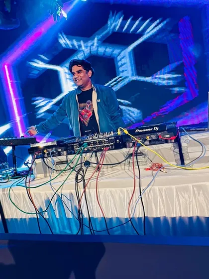 In my element at a wedding event. The vibrant blue and pink lighting combined with the geometric visuals on the screen created a fantastic backdrop for my DJ set.