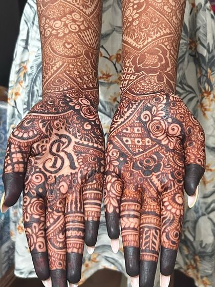 A stunningly dark stain that makes the groom's initial pop. The contrast between the detailed patterns and the dark fingertips is a classic bridal look.