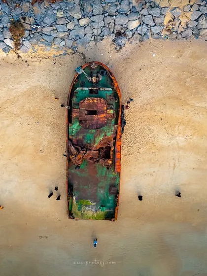 A top-down aerial view of a shipwreck, used here with a poem about the sea. The abstract nature of the shot complements the reflective text.
