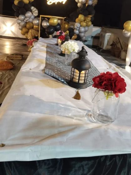 A close-up of the low seating arrangement under the terrace canopy, with lanterns and flower vases creating a cozy and intimate atmosphere.
