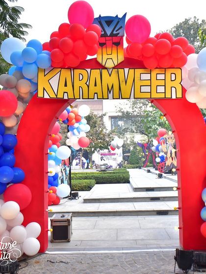 The grand entrance to the Transformers party, featuring a massive red arch with the birthday boy's name and a cascade of red, white, and blue balloons.