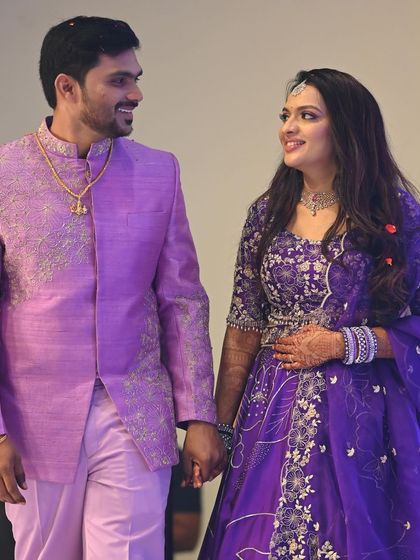 The happy couple walking hand-in-hand at their reception. The bride's glamorous makeup and hairstyle perfectly match the celebratory mood of the evening.